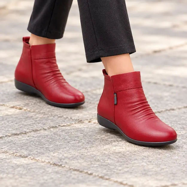 bottines femme rouges fourrees et compensees portees en marchant avec un pantalon sombre 45072