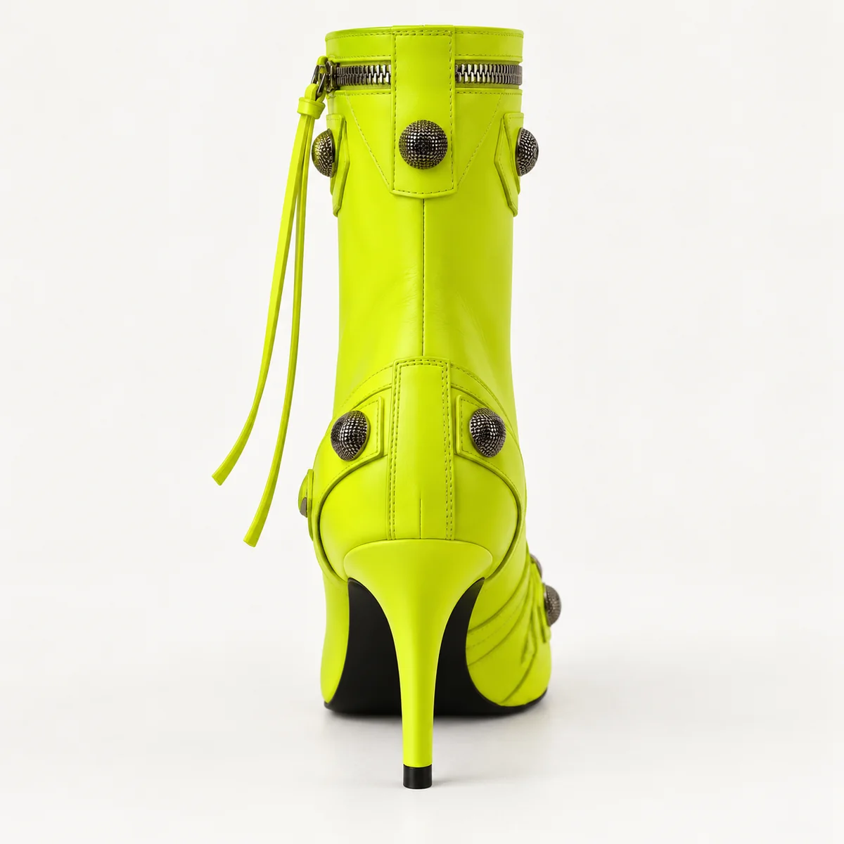 Femme portant bottines vertes à rivets et talon aiguille élégantes