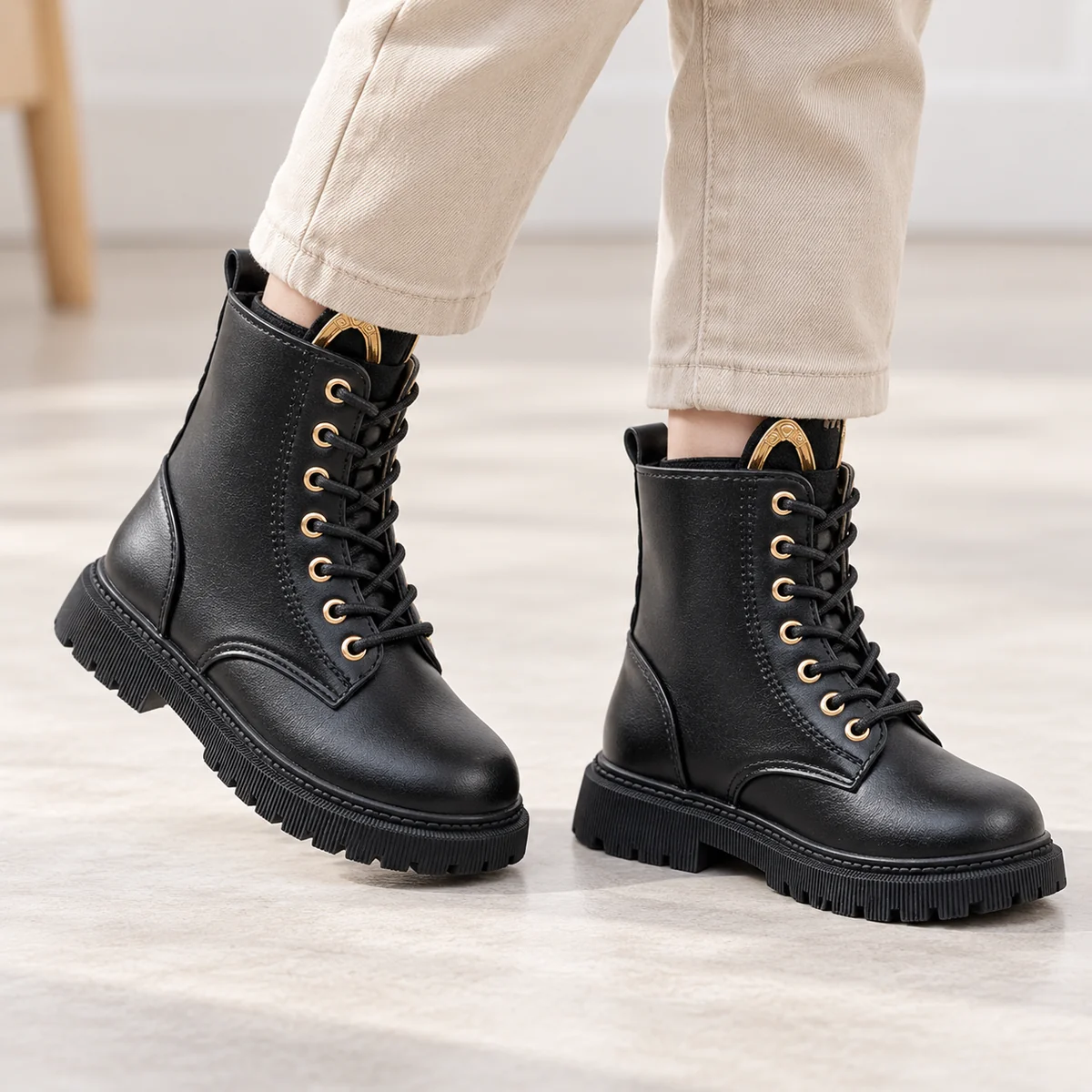 Jeune fille portant des bottines noires à lacets zip et semelle crantée pour fille