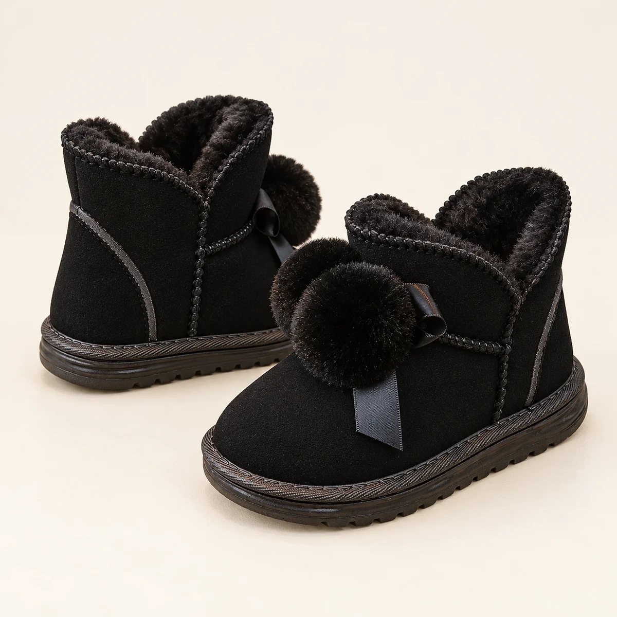 Défilé de bottines noires pour fille avec détails en pompons