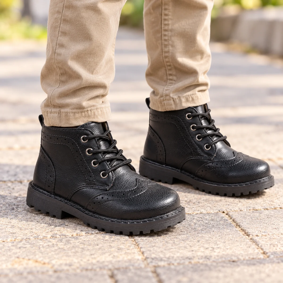 Jeune garçon portant des bottines noires à lacets avec semelle antidérapante