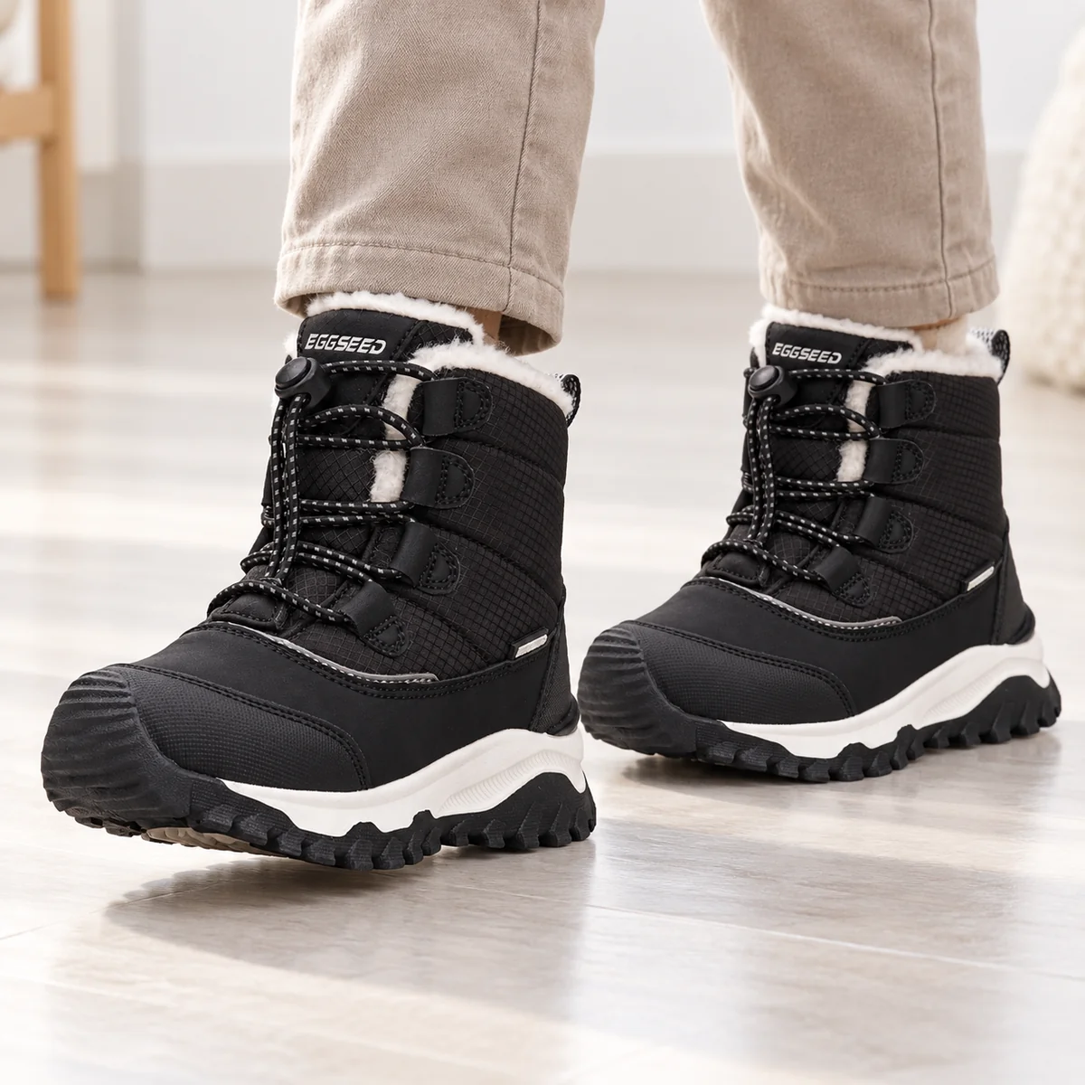 Jeune garçon portant des bottines noires fourrées à lacets