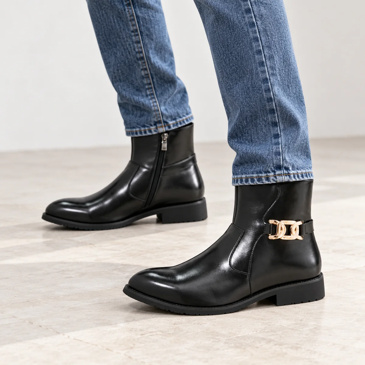 Zoom sur bottines homme noires avec détails dorés en cuir brillant
