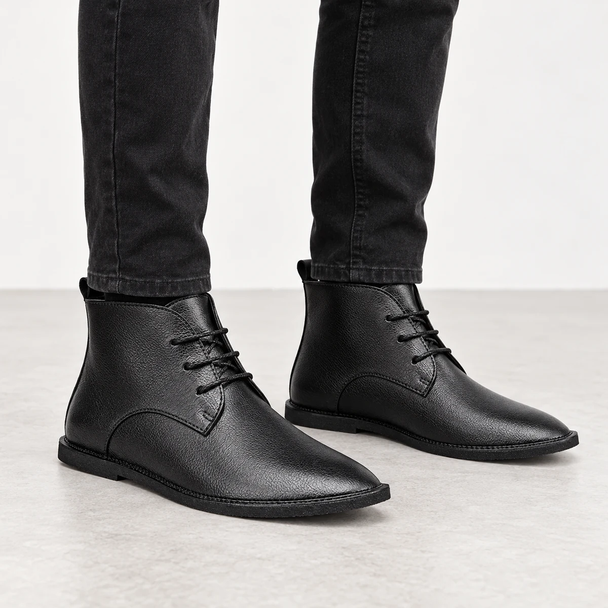Vue rapprochée des bottines noires minimalistes à lacets pour homme