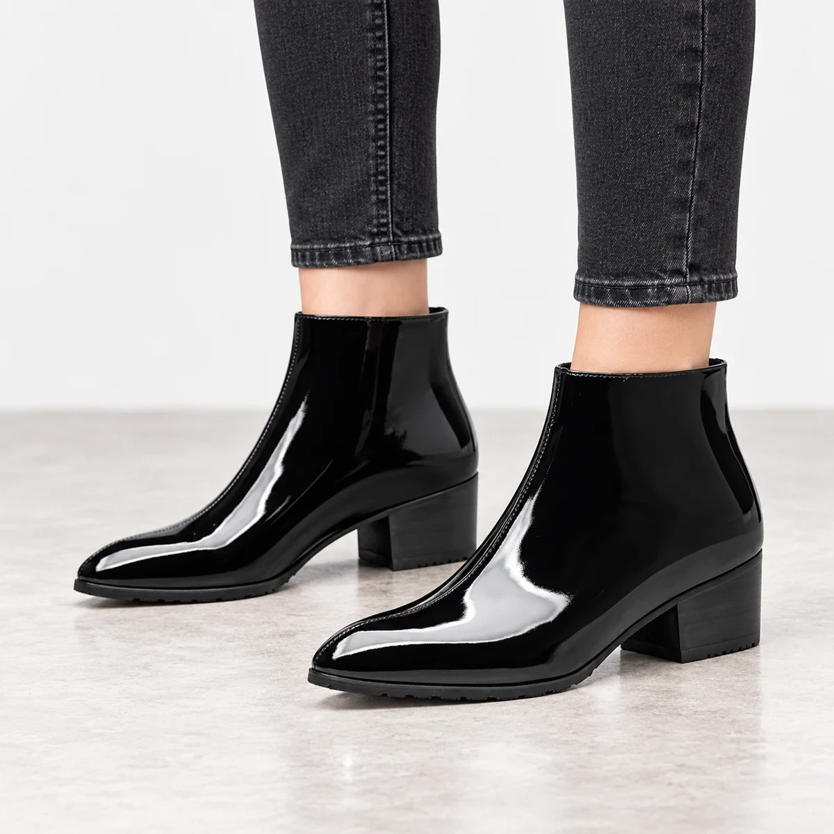 Vue de face de bottines noires vernies pour homme avec zip pratique