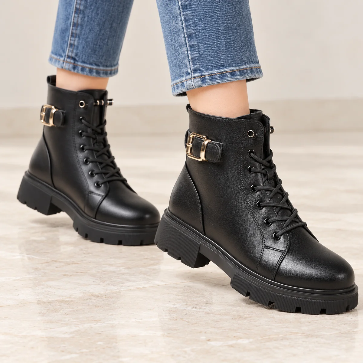 Femme portant des bottines motardes noires avec boucle et lacets